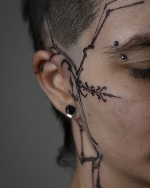 Ornamental branch-like tattoo from temple to neck by Zuzana Mala